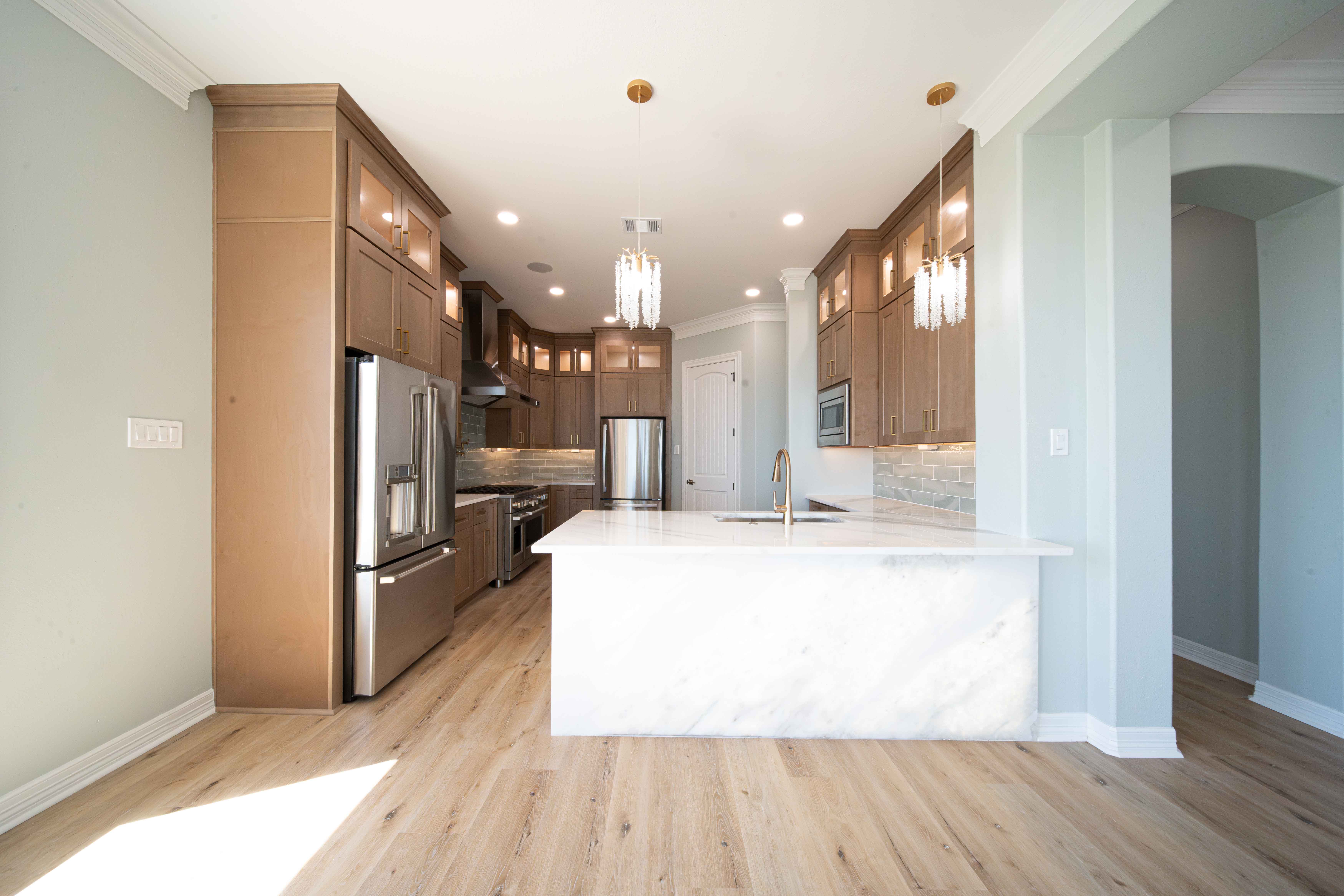 Kitchen with wood cabinetry and marble island